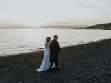 married couple walking along largs beach in ayrshire