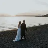 married couple walking along largs beach in ayrshire