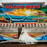 married couple in front of largs beach wave ride