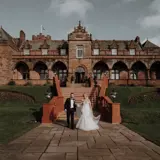 Moody Wide Angle Photograph of Boclair House with Bride and Groom below steps