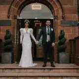 Boclair House Bearsden: A couple stand holding hands in front of the Wedding Venue in Glasgow